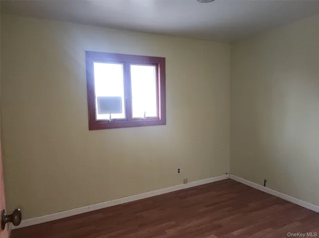 a view of a small space with wooden floor and a window