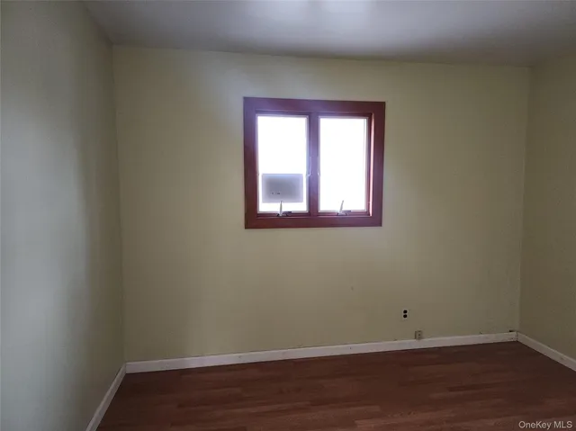 a view of a small space with wooden floor and a window