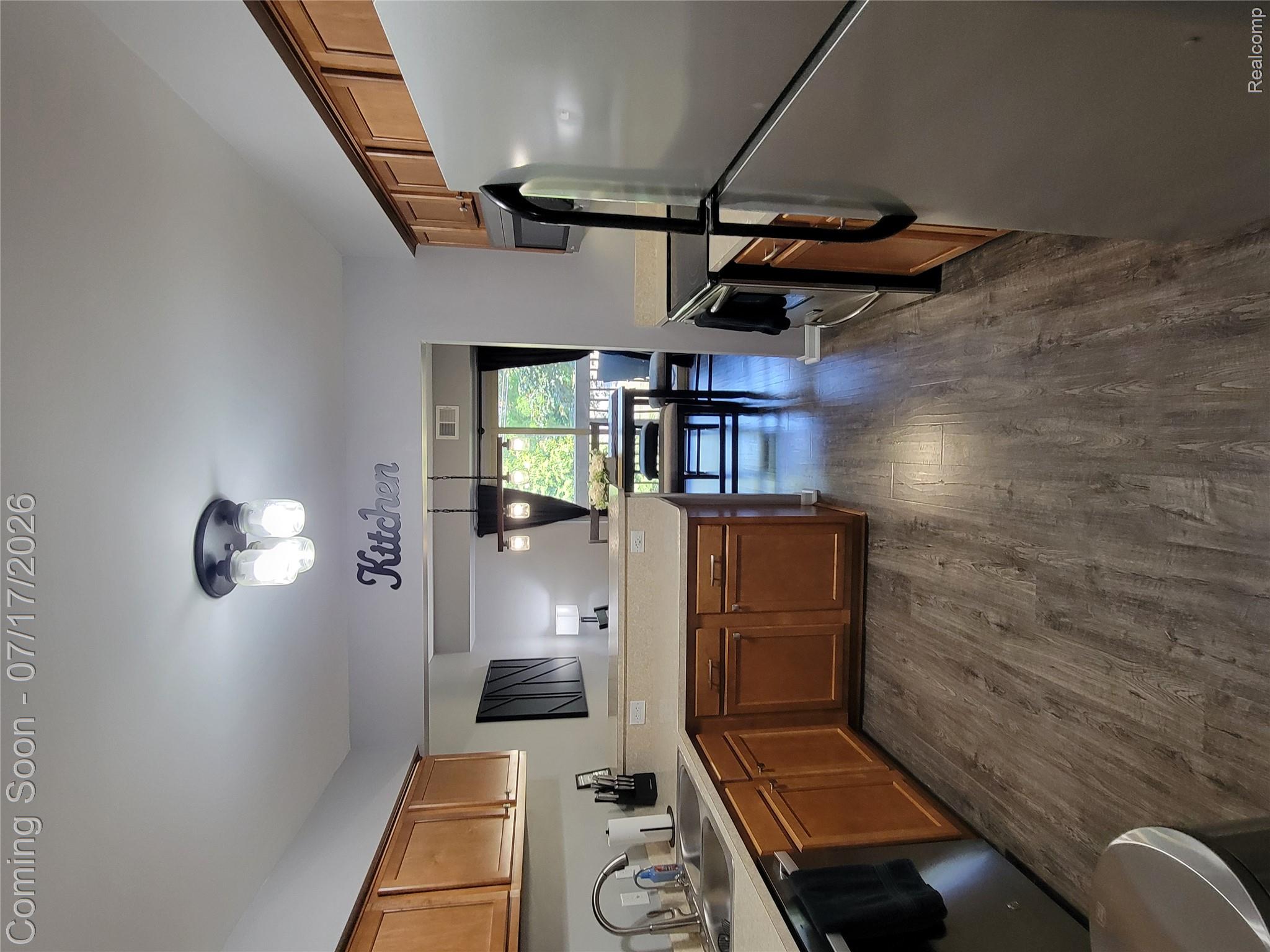Kitchen featuring wood-finish flooring, light-toned countertops, and wood cabinetry