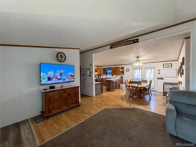 a living room with furniture a flat screen tv and a wall painting
