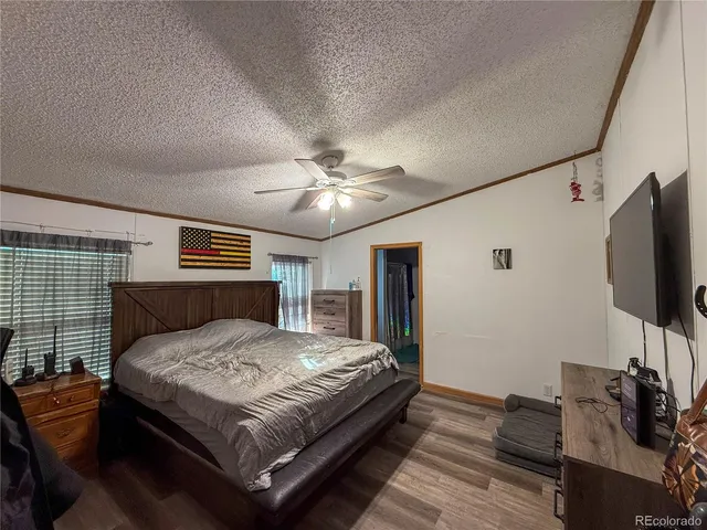 a bedroom with a bed and a flat tv screen on dresser