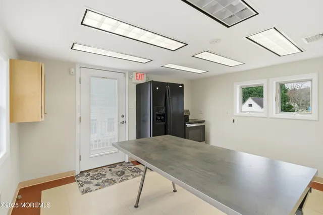a view of a hallway with a dining table and chairs