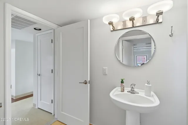 a bathroom with a sink a mirror and a light fixture