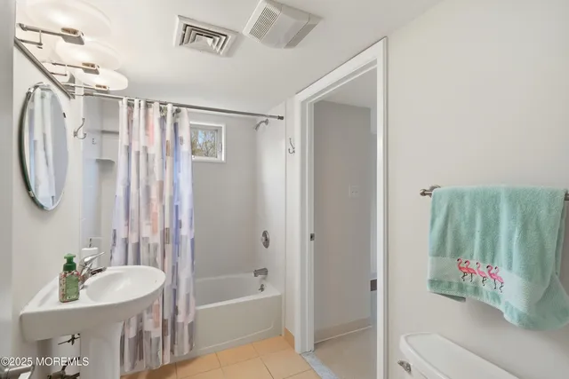 a bathroom with a tub a sink and a mirror