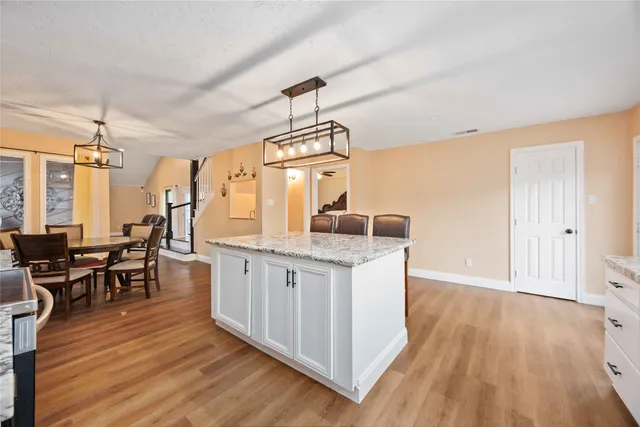 a kitchen with granite countertop a dining table chairs wooden floor and granite top