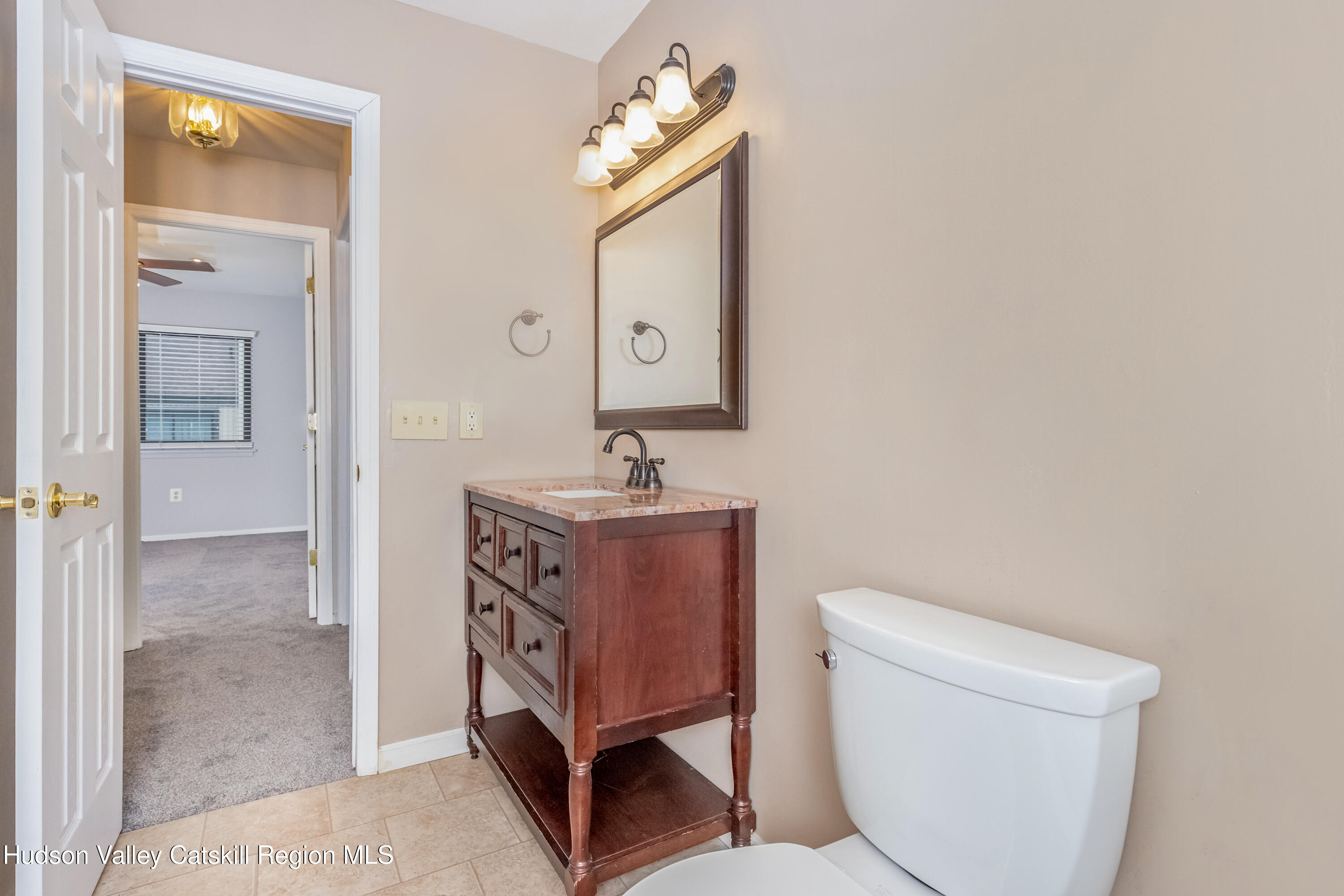 1907 Magnolia Walk Poughkeepsie, NY 12603 - Photo 30 of 36 a bathroom with a toilet a sink and mirror