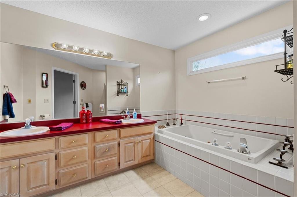 6933 Lawrence Farm Lane Randleman, NC 27317 - Photo 18 of 33 PRIMARY BATHROOM WITH A JETTED TUB, DOUBLE SINKS AND LOTS OF COUNTER AND CABINET SPACE.