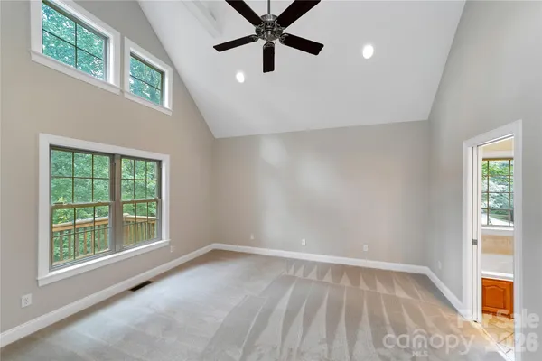 a view of an empty room with a window and a ceiling fan