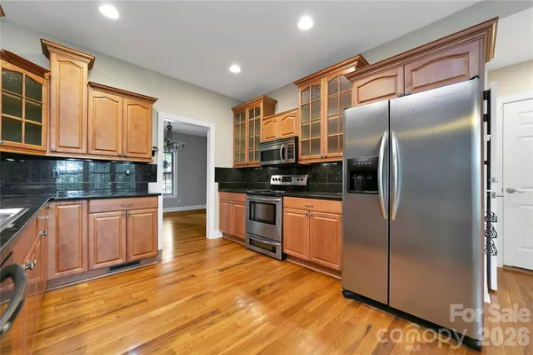a kitchen with granite countertop a refrigerator and a stove top oven