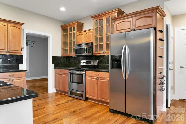 a kitchen with stainless steel appliances granite countertop a refrigerator and a stove top oven