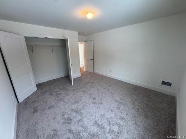 11 Colonels Path Manorville, NY 11949 - Photo 37 of 49 Unfurnished bedroom featuring a large closet and gray soft plush carpet