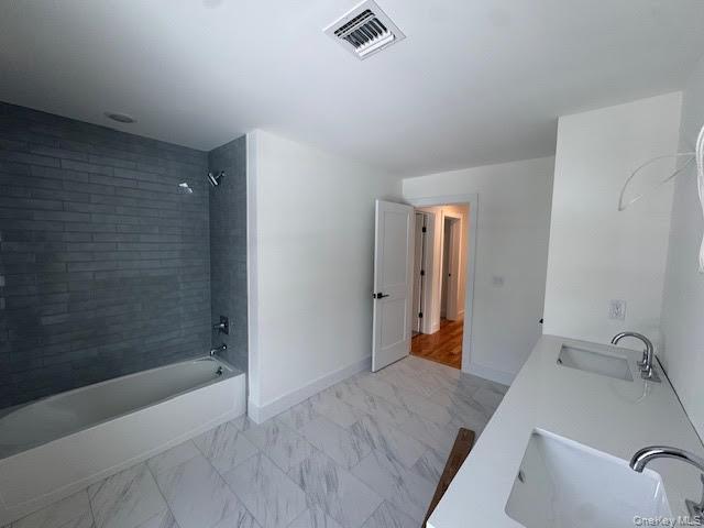 11 Colonels Path Manorville, NY 11949 - Photo 40 of 49 Full bath with double vanity, bathing tub / shower combination, and light marble finish flooring