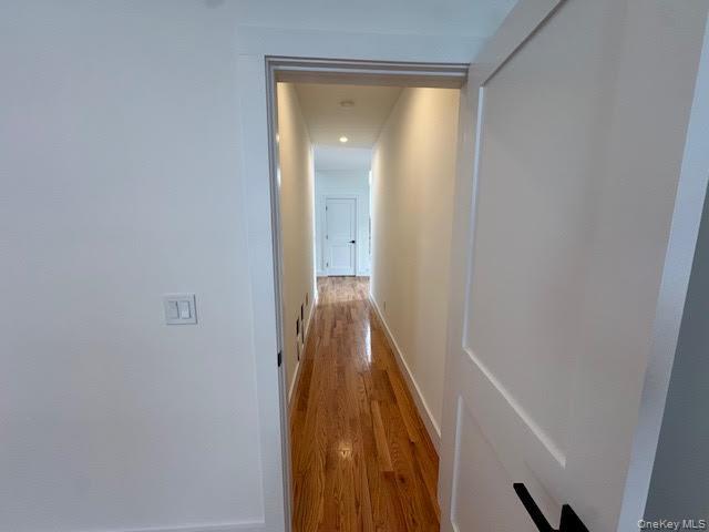 11 Colonels Path Manorville, NY 11949 - Photo 6 of 49 Corridor that leads to the primary suite with wood finished floors and recessed lighting