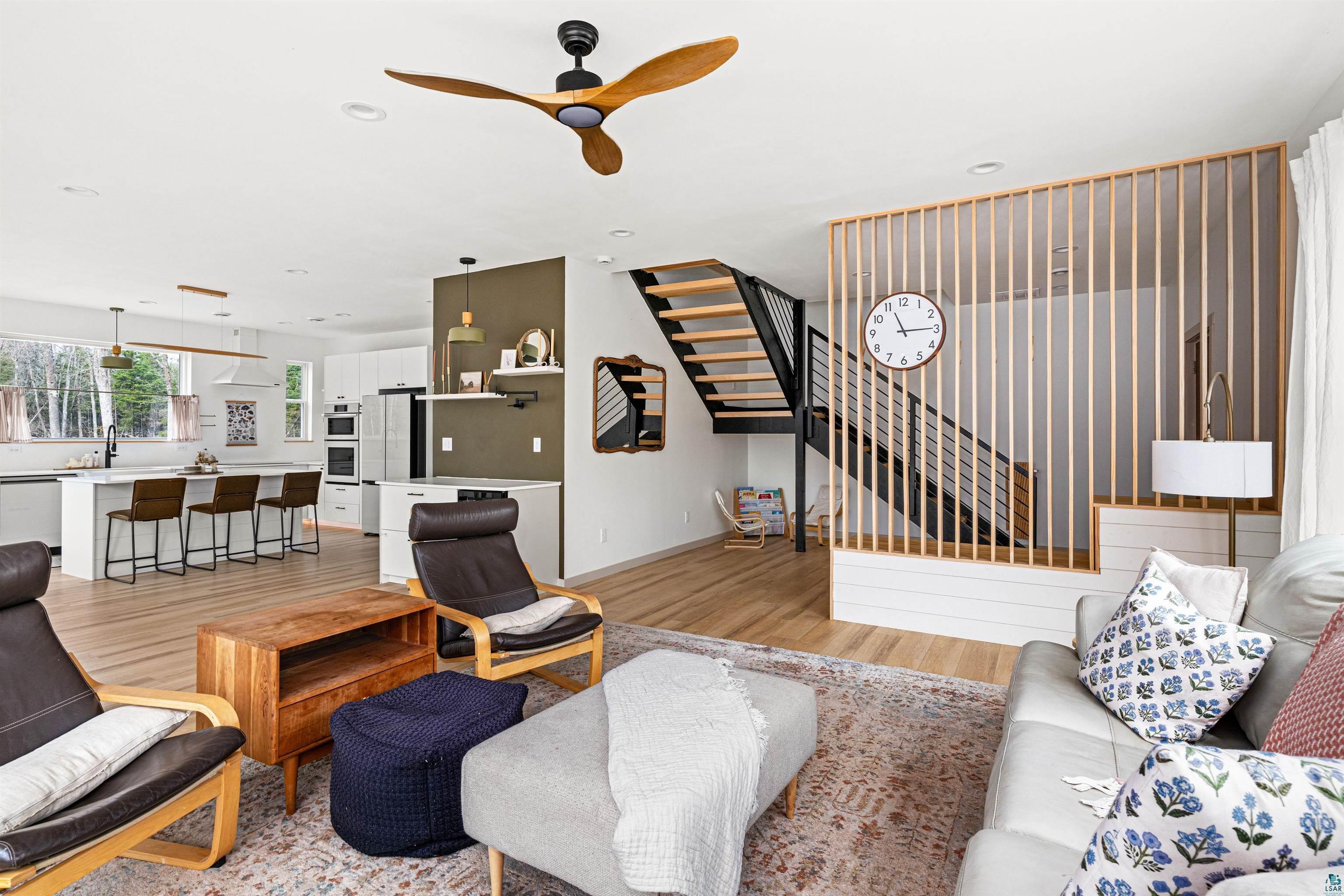 1825 East Shilhon Road Duluth, MN 55804 - Photo 11 of 37 Open-concept living space featuring vinyl flooring, a modern wooden ceiling fan, and a contemporary slatted wood room divider