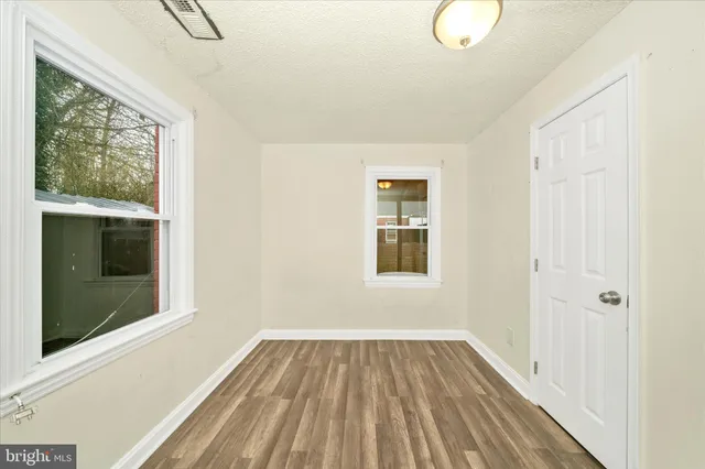 a view of a room with wooden floor and windows