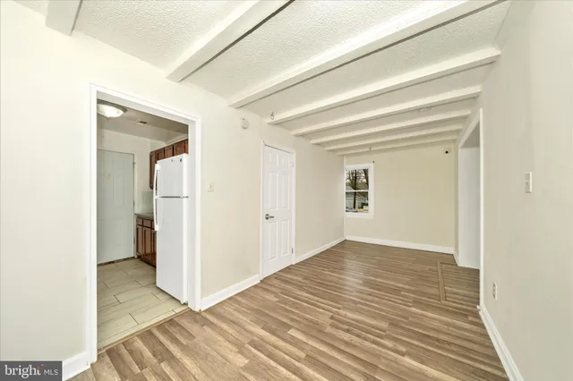 a view of a room with wooden floor and a hallway