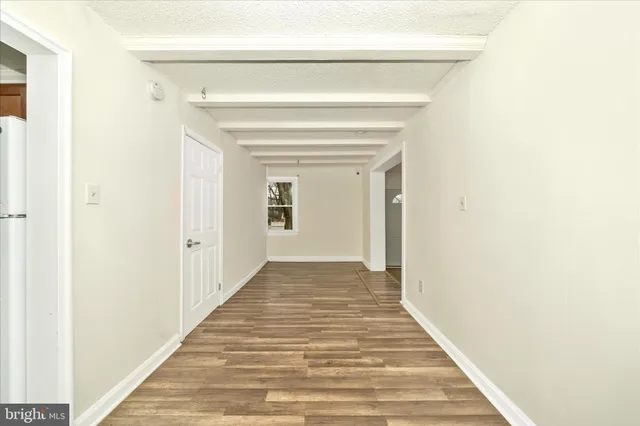 a view of a hallway with wooden floor