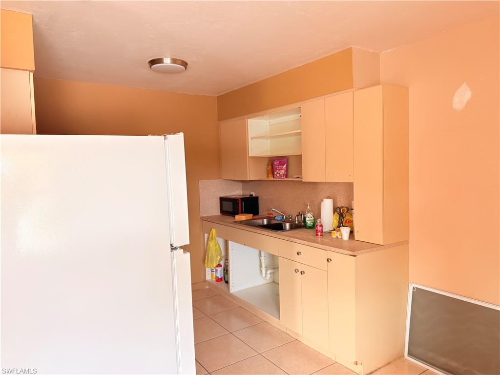 2241 Sunshine Boulevard Naples, FL 34116 - Photo 8 of 35 a kitchen with kitchen island a sink a stove a refrigerator a counter top space and cabinets