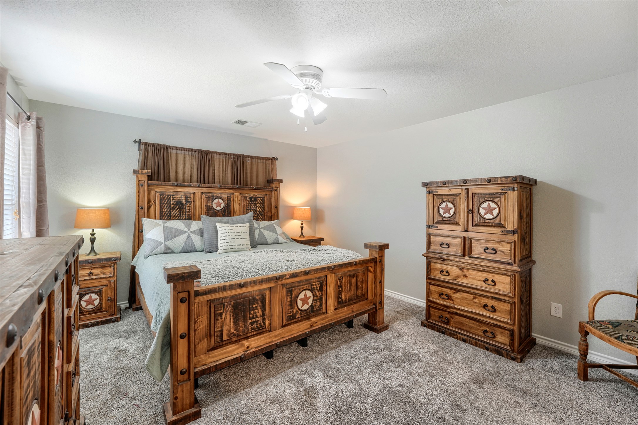 1105 2nd Street Jarrell, TX 76537 - Photo 13 of 27 Relax in comfort in this primary bedroom, featuring plush carpeting and an overhead ceiling fan.