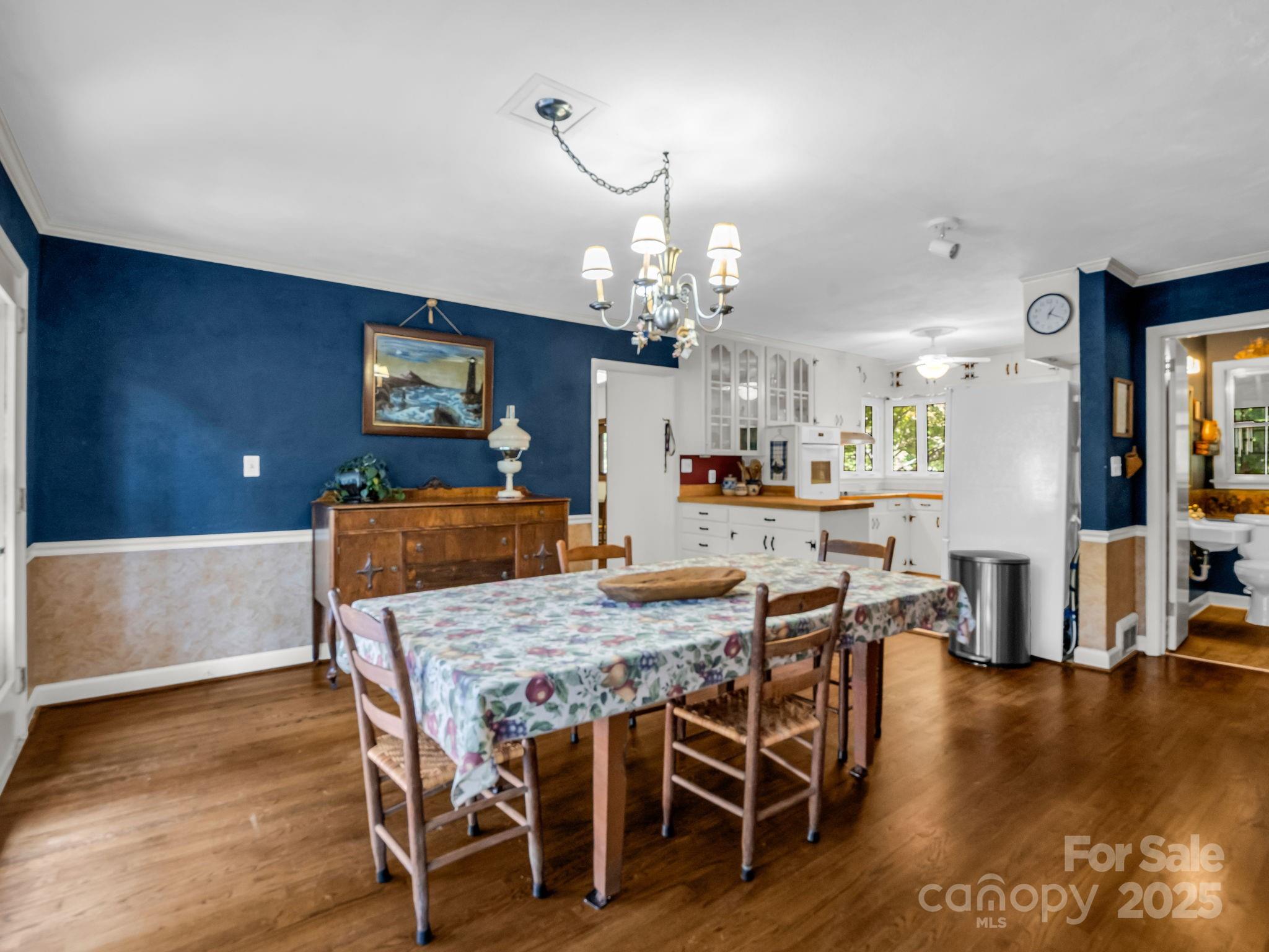 821 Warrior Drive Tryon, NC 28782 - Photo 13 of 44 a dining room with wooden floor a chandelier a wooden table and chairs