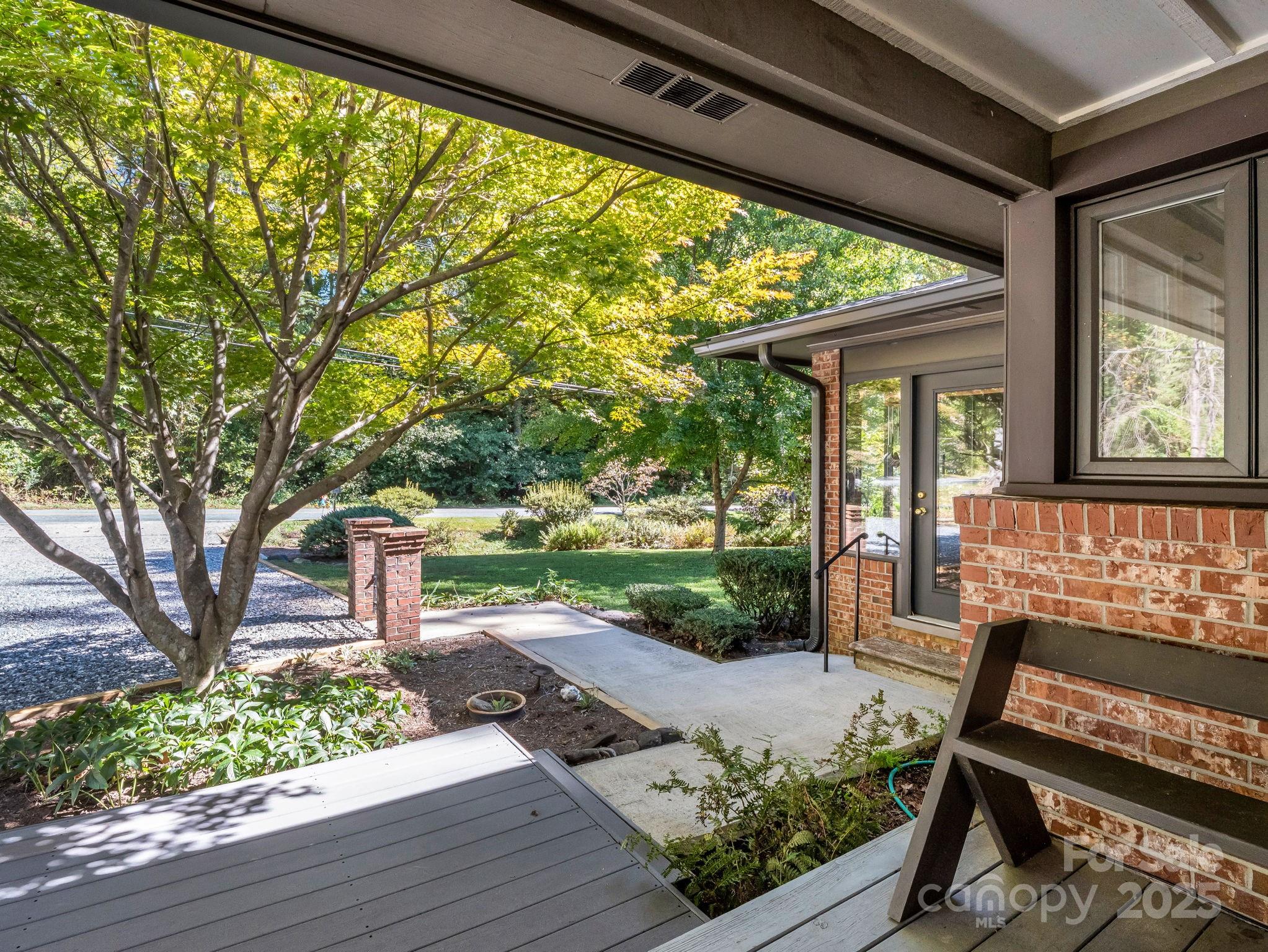 821 Warrior Drive Tryon, NC 28782 - Photo 35 of 44 a porch with a bench and floor to ceiling window