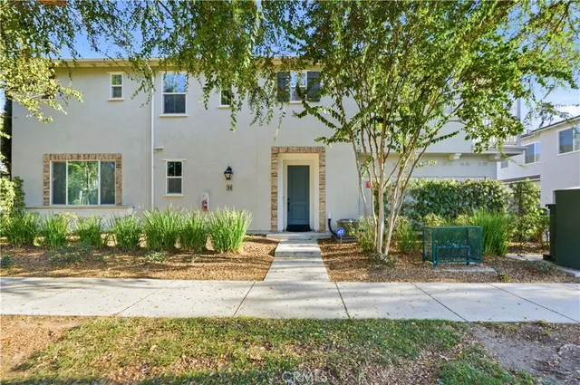 a front view of a house with garden and plants