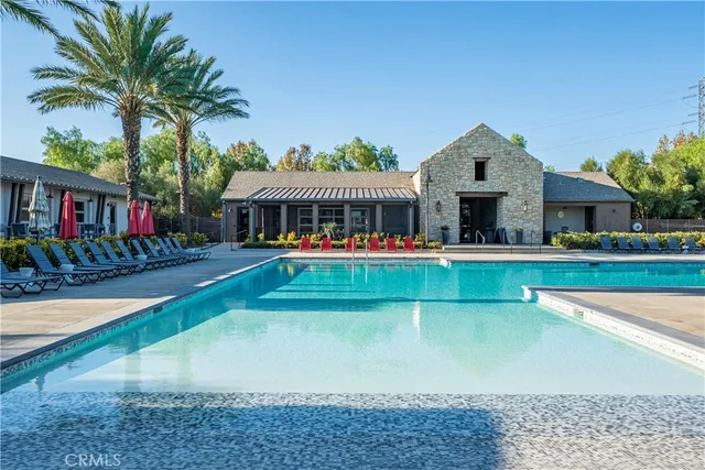 a view of an house with swimming pool and chairs
