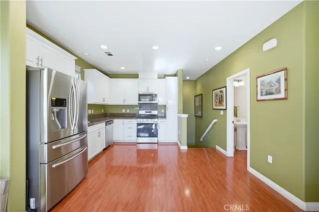 a kitchen with stainless steel appliances granite countertop a refrigerator and a stove top oven
