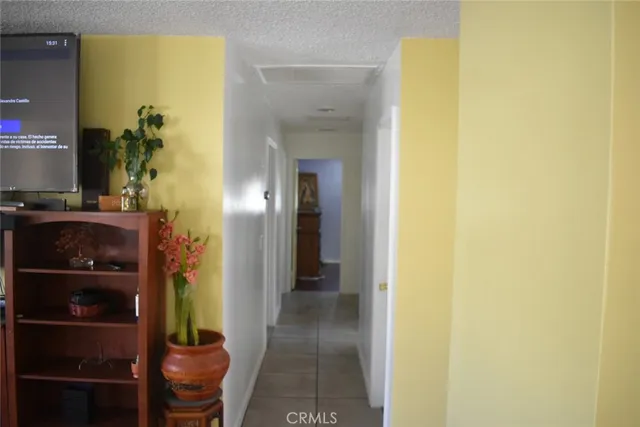 a view of a hallway with wooden floor and a bathroom