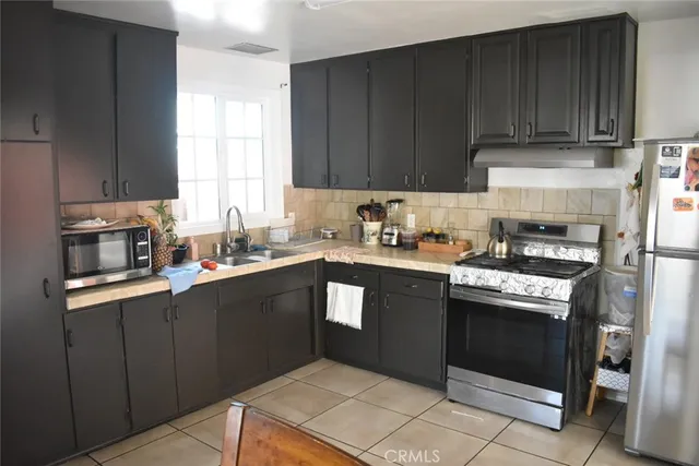 a kitchen with a sink dishwasher stove and cabinets