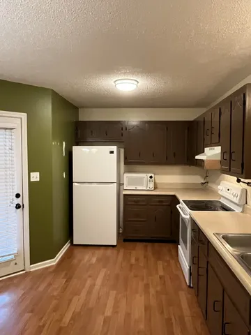 a kitchen with a sink a stove top oven and refrigerator