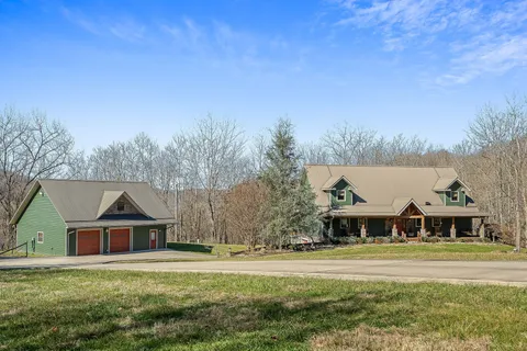 a front view of house with yard and trees in the background