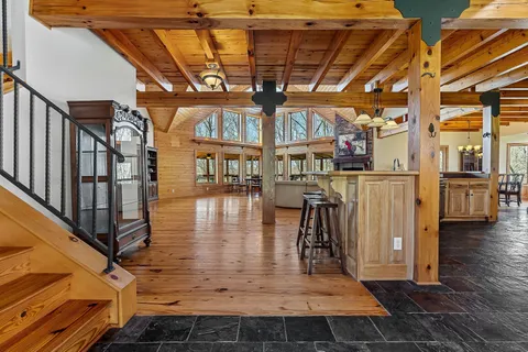 a kitchen with kitchen island granite countertop a table chairs sink and cabinets