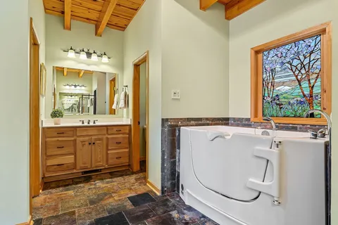a bedroom with a bed chandelier and a window