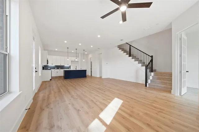 a view of empty room with wooden floor and windows
