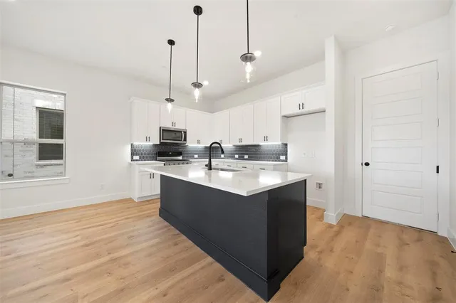 a large kitchen with kitchen island a sink stainless steel appliances and cabinets
