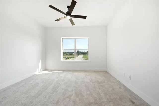 an empty room with a window and a fan