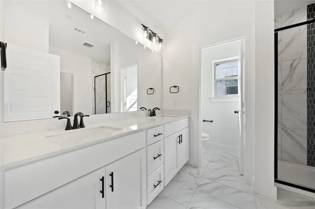 a spacious bathroom with double sink and a mirror