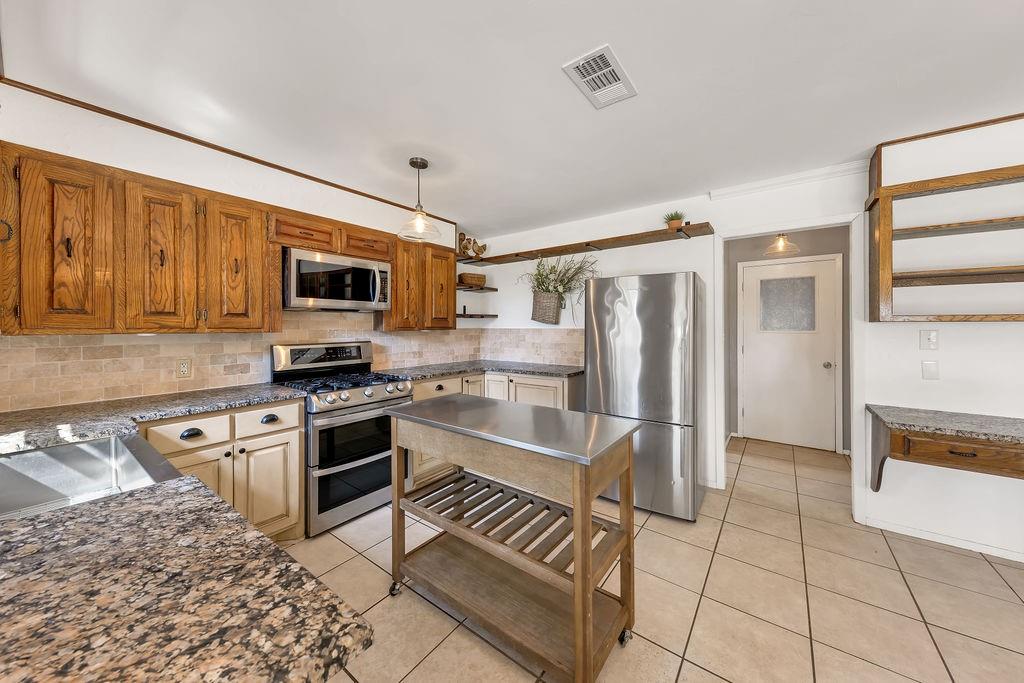 473 County Rd SE 3370 Winnsboro, TX 75494 - Photo 11 of 40 a kitchen with stainless steel appliances granite countertop a refrigerator and a stove top oven