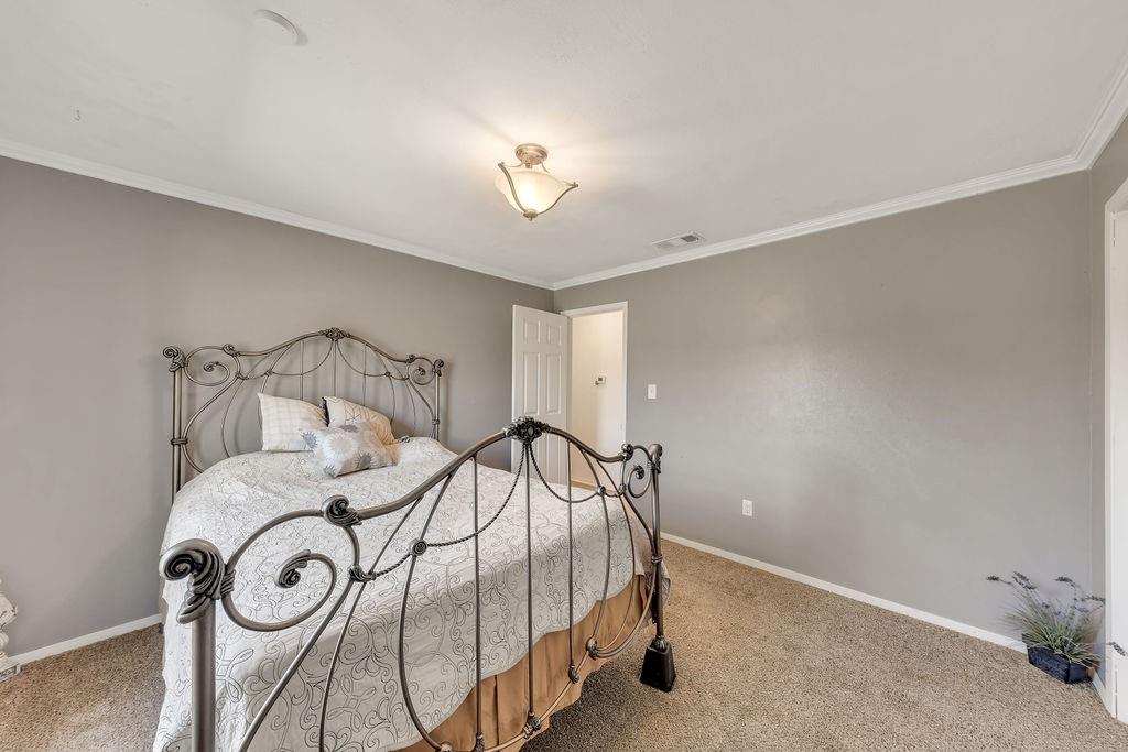 473 County Rd SE 3370 Winnsboro, TX 75494 - Photo 21 of 40 a bedroom with a bed and a chandelier