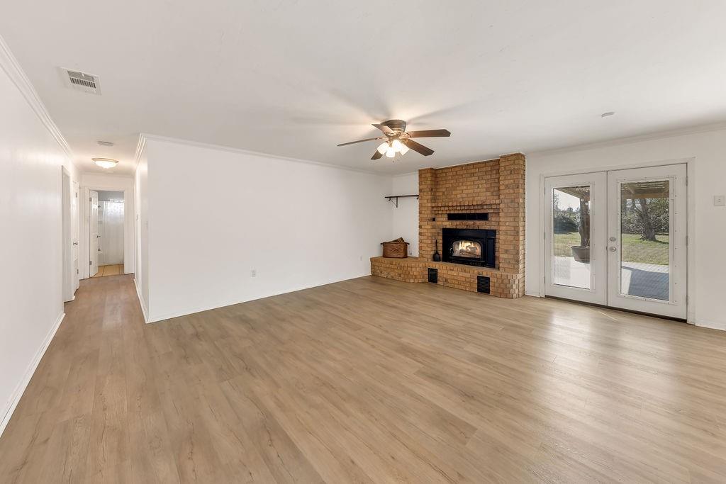 473 County Rd SE 3370 Winnsboro, TX 75494 - Photo 6 of 40 a view of a livingroom with a fireplace a chandelier and wooden floor