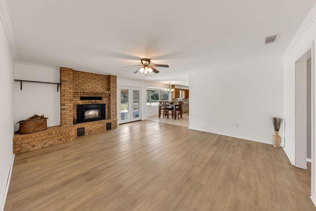 473 County Rd SE 3370 Winnsboro, TX 75494 - Photo 8 of 40 a view of a livingroom with a fireplace a ceiling fan and wooden floor