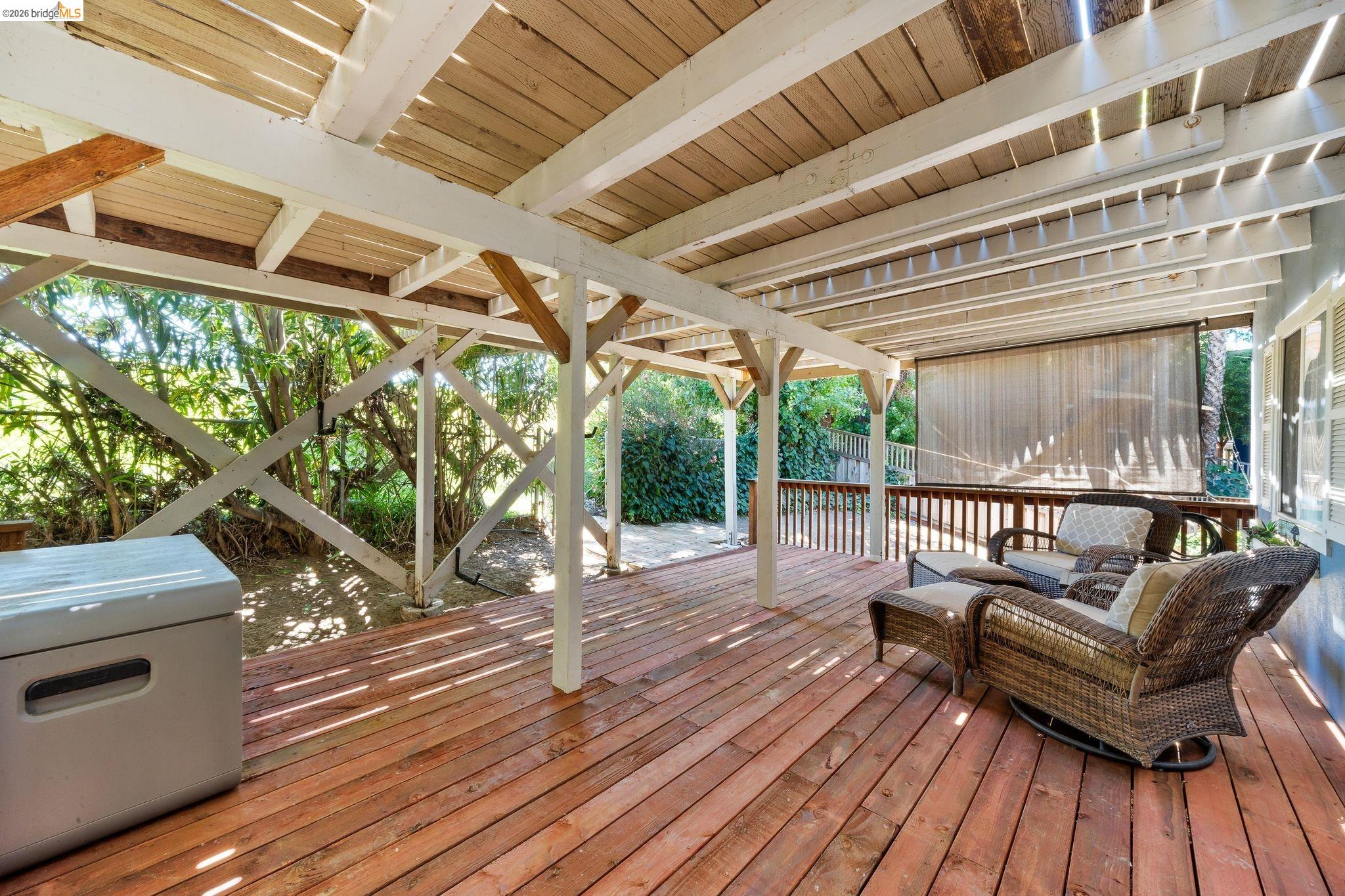 1704 Taylor Road Bethel Island, CA 94511 - Photo 42 of 73 Spacious covered wood deck with exposed beam ceiling, white support columns, and wood plank flooring