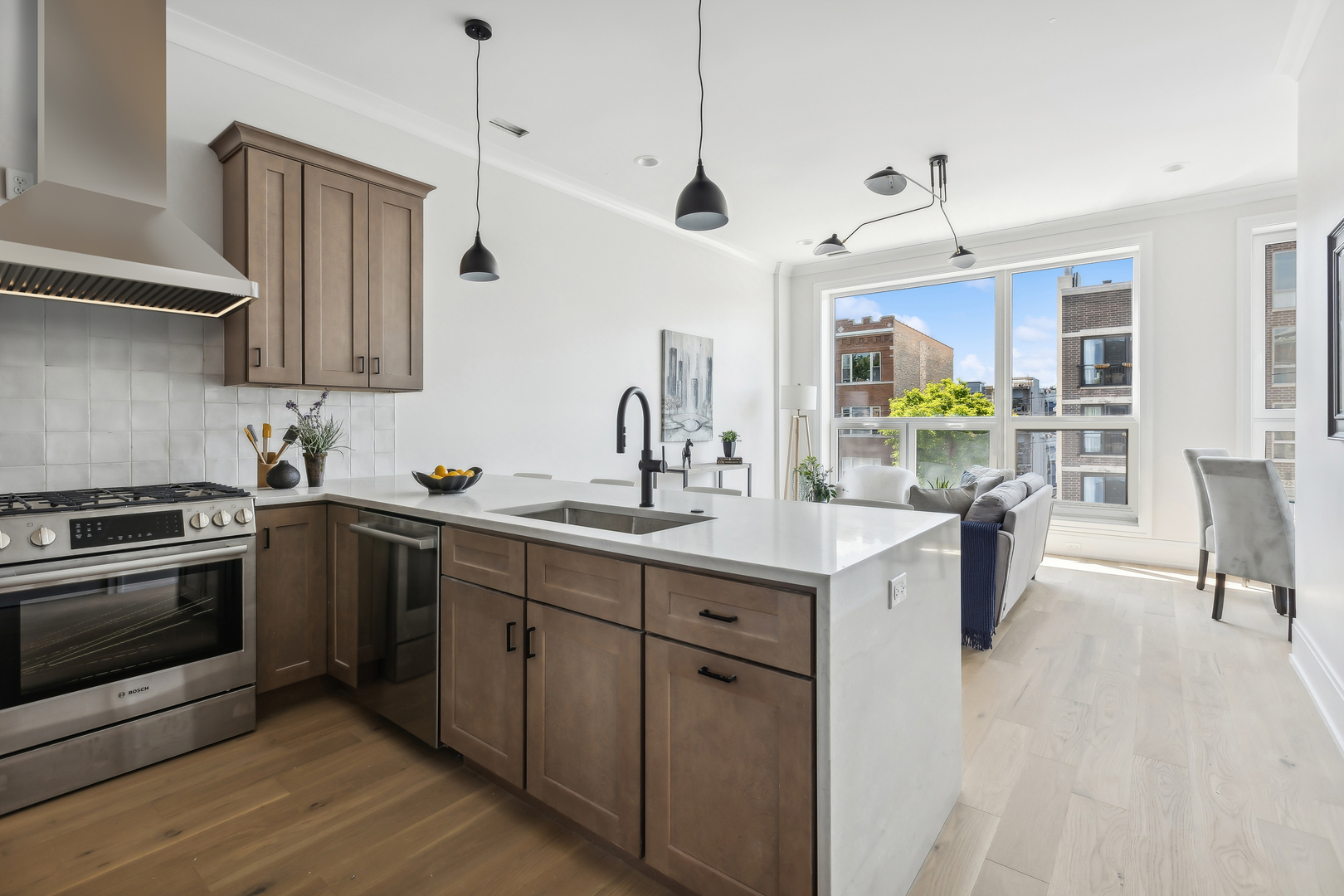 2426 West Augusta Boulevard, Unit 2 Chicago, IL 60622 - Photo 11 of 20 a kitchen with kitchen island granite countertop a sink cabinets and stainless steel appliances