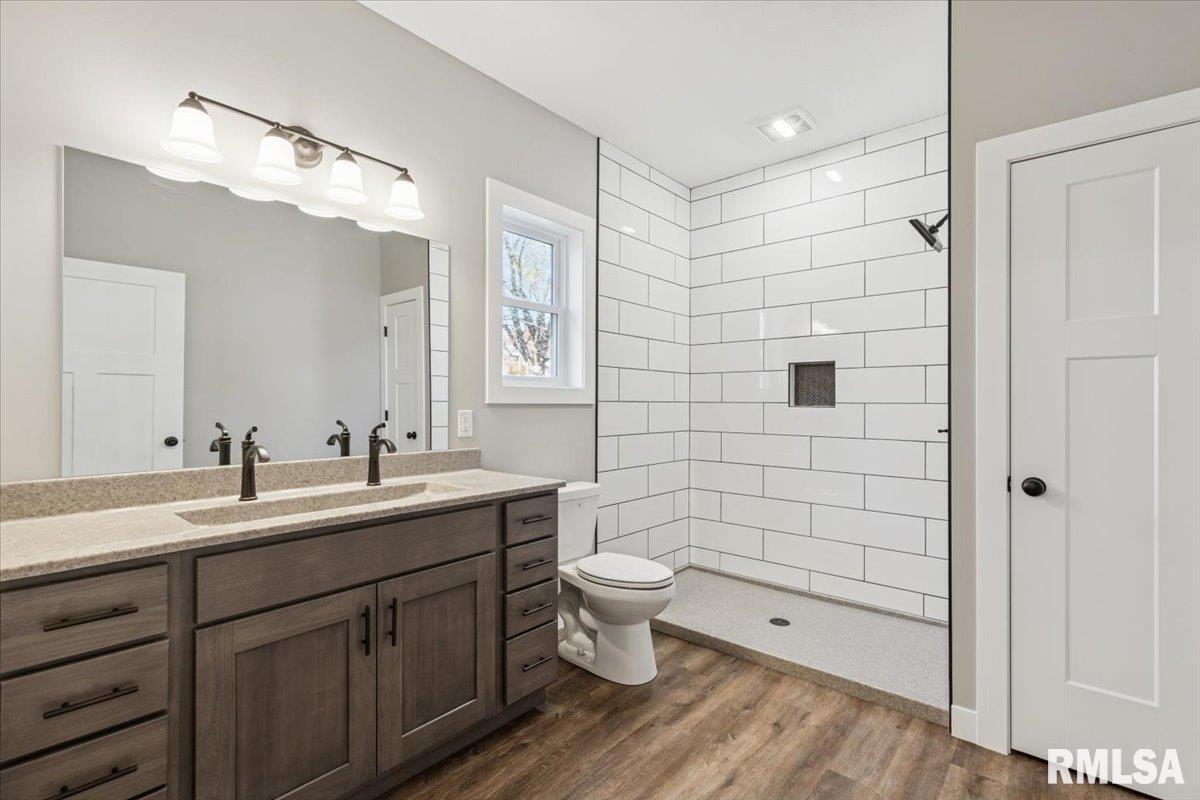1323 5th Avenue De Witt, IA 52742 - Photo 16 of 28 a bathroom with a double vanity sink toilet mirror and shower