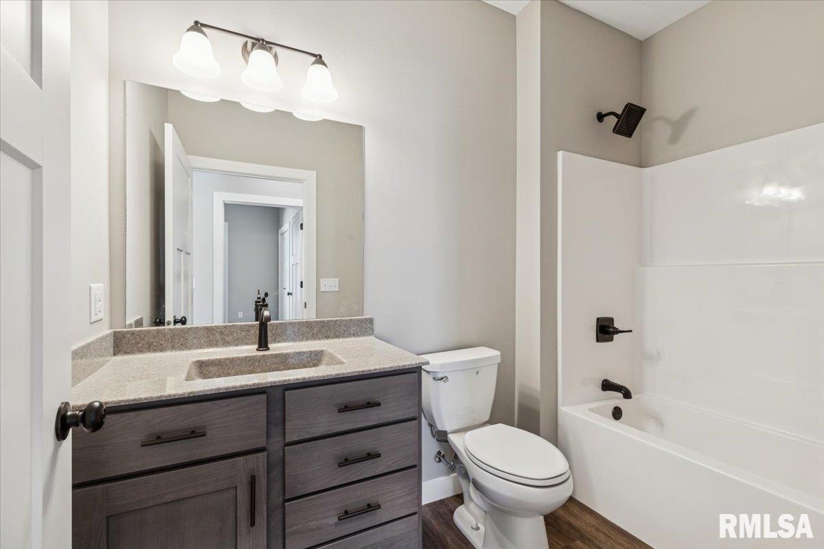 1323 5th Avenue De Witt, IA 52742 - Photo 24 of 28 a bathroom with a granite countertop toilet sink and mirror