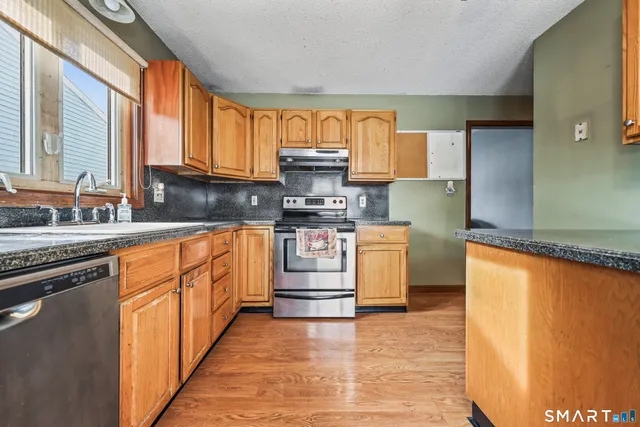 a kitchen with stainless steel appliances granite countertop a stove a sink and a refrigerator