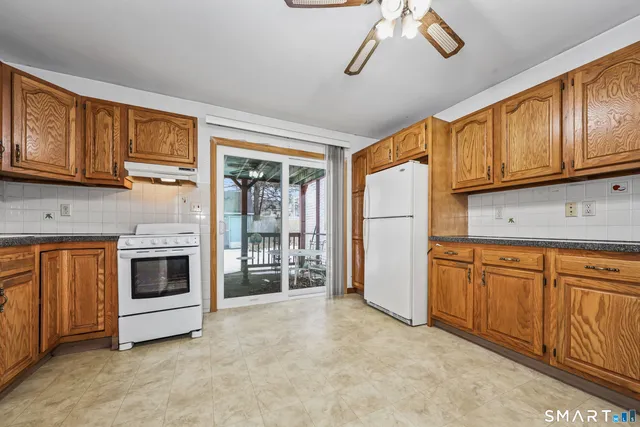 a kitchen with stainless steel appliances granite countertop a refrigerator a stove a sink dishwasher and wooden cabinets