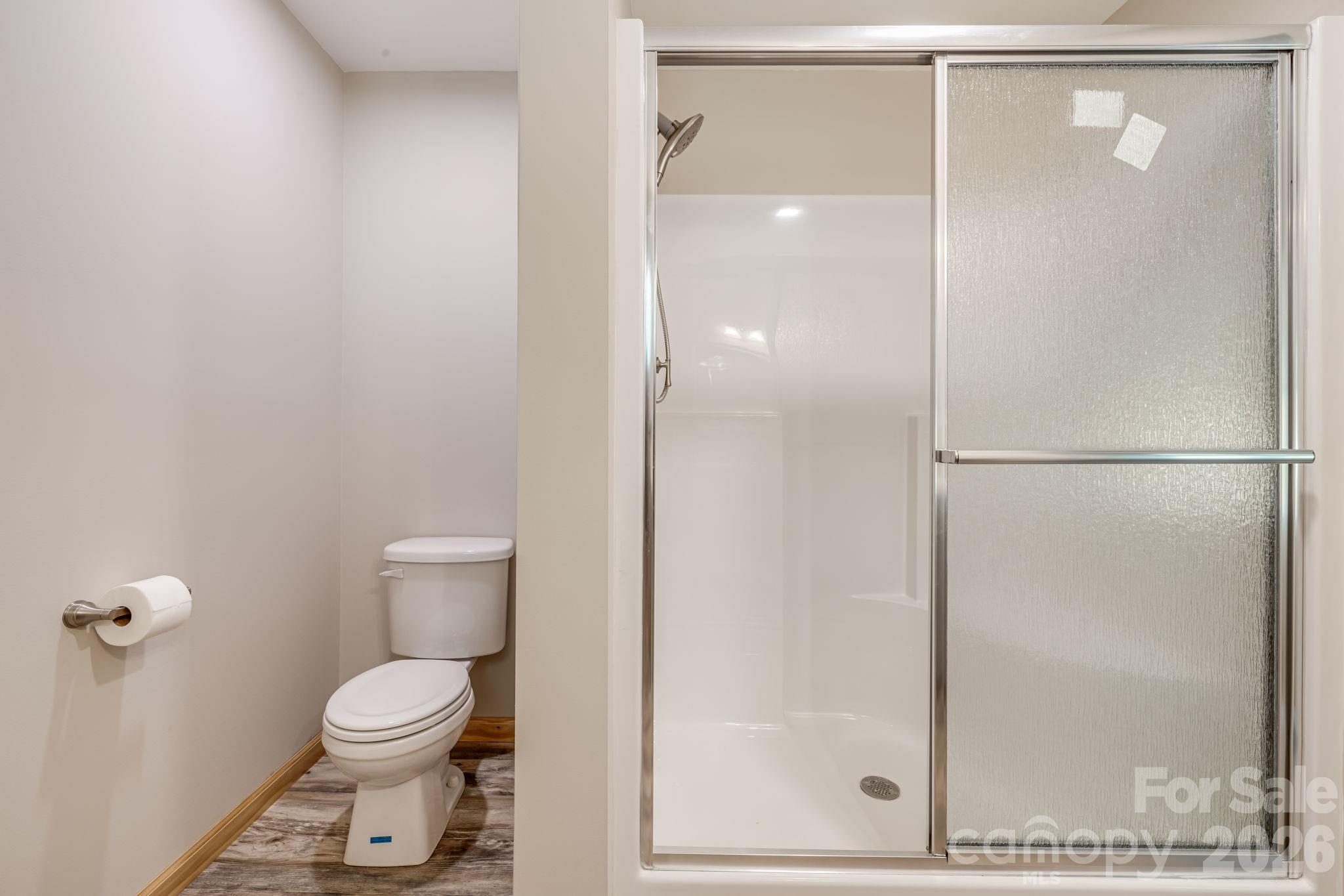 35 Byrd Road Candler, NC 28715 - Photo 24 of 43 a bathroom with a toilet and a glass shower door