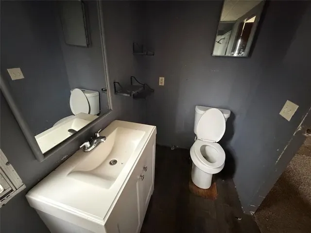 a bathroom with a toilet sink and mirror